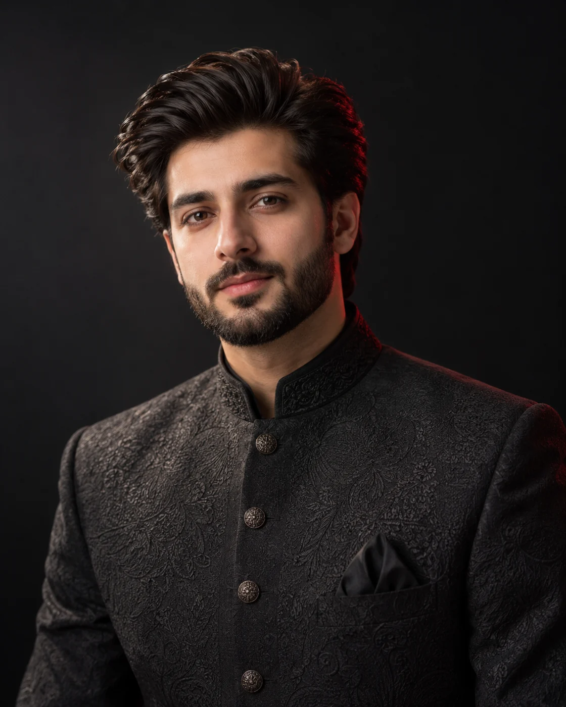 Swept-back dark wedding hairstyle and close beard worn with a charcoal achkan